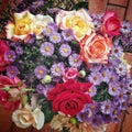 flowers bouquet made of violet chrysantemums, red, yellow and white roses on a brick background Royalty Free Stock Photo