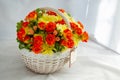 Flowers bunch wicker basket, with red roses and yellow chrysanthemums in gift box Royalty Free Stock Photo