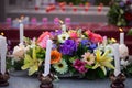 Flowers on the tomb at the cemetery with burning white candle Royalty Free Stock Photo