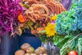 Flowers in canning jars and buckets and vegetables and fruit at farmers market with rich colors including purple and green Royalty Free Stock Photo