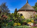 Flowers by circular stone building in botanical garden