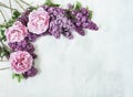 Flowers composition. Branches of lilac flowers of lilac and delicate pink peonies on a gray background. Royalty Free Stock Photo