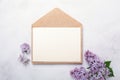 Flowers composition. Envelope, sheet of paper and lilac flowers and on stone background. Template for your invitation or