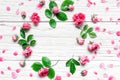 Flowers composition. Frame made of fresh rose flowers on white wooden background. Flat lay. mock up