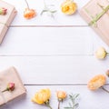 Flowers composition. Gifts and rose flowers on white wooden table. Women Day. Flat lay, top view