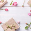 Flowers composition. Gifts and rose flowers on white wooden table. Women Day. Flat lay, top view Royalty Free Stock Photo