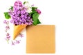 Flowers composition. Lilac in waffle cone and postcard of kraft paper on white background. Flat lay, top view, copy