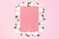 Flowers composition. Pink blank paper, white fresh roses and green leaves on gentle pink background. Flat lay, top view, copy Royalty Free Stock Photo