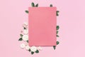 Flowers composition. Pink blank paper, white fresh roses and green leaves on gentle pink background. Flat lay, top view, copy Royalty Free Stock Photo