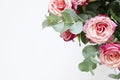 Flowers composition. Roses flowers and branch eucalyptus on white background. Top view, copy space.