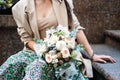 Flowers delivery. Faceless portrait of woman with receiving beautiful flowers bouquet from delivery outdoors