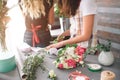 Flowers delivery top view. Florists creating order, making rose bouquet in flower shop. Two female florists are doing Royalty Free Stock Photo