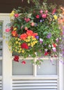 Flowers in the hanging basket with window. Royalty Free Stock Photo