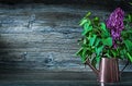 Flowers of lilac in bronze watering can on vintage wood Royalty Free Stock Photo