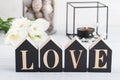 Flowers and lit candle, wooden letter Love Royalty Free Stock Photo