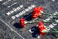 Flowers on the memorial to fallen soldiers, red carnations on black marble, Russian text of soldiers military rank - sergeant,