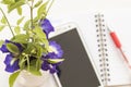 Flowers and mobile with notebook on table white