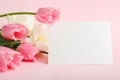 Flowers mock up congratulation. Congratulations card in bouquet of pink tulips on pink background. White blank card with space for Royalty Free Stock Photo
