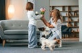 With flowers. Mother with her daughter and with two cute dogs is in domestic room Royalty Free Stock Photo