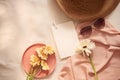 Flowers on the plate with hat, galsses and card on the light background