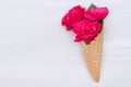 Flowers red roses in a waffle cone on white wooden background. Flat lay, top view, floral background Royalty Free Stock Photo