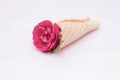 Flowers red roses in a waffle cone on white wooden background. Flat lay, top view, floral background, toned Royalty Free Stock Photo