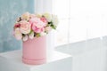 Flowers in round luxury present box. Bouquet of pink and white peonies in paper box near the window.Mock-up of hat box