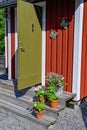 Flowers on stairs infront of a red wooden cabin