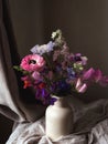 Flowers Still life. Beautiful colorful flowers in vase on moody background. Stylish artistic composition of lathyrus, anemone, Royalty Free Stock Photo