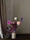 Flowers Still life. Beautiful flowers in vase on moody rustic background. Stylish artistic composition of lathyrus, anemone, Royalty Free Stock Photo