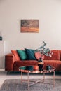 Flowers in stylish vase on small coffee table in bright living room