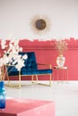 Stylish vase on trendy coffee table next to petrol blue settee in fancy living room interior