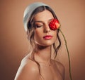 Flowers, thinking and woman with makeup beauty, floral wellness and creative on a brown studio background. Peace, flower