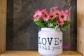 flowers in a tin bucket with a phrase & x22; Love is all You Need& x22;