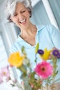 Flowers to brighten up your day. a senior woman enjoying some flower arranging at home. Royalty Free Stock Photo