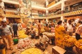 Flowers traders selling colorful floral garlands inside crowded city market