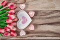 Flowers tulips, a heart-shaped plate and a heart-shaped candle. Festive background to the St. Valentine`s Day in pink colors. Royalty Free Stock Photo