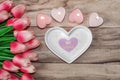 Flowers tulips, a heart-shaped plate and a heart-shaped candle. Festive background to the St. Valentine`s Day in pink colors. Royalty Free Stock Photo