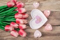 Flowers tulips, a heart-shaped plate and a heart-shaped candle. Festive background to the St. Valentine`s Day in pink colors. Royalty Free Stock Photo