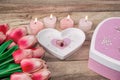 Flowers tulips, a heart-shaped plate with a ring in the middle, a heart-shaped candle and a gift. Festive background to the St. Royalty Free Stock Photo