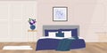 Flowers in vase on bedside table next to king size bed with navy blue bedding Royalty Free Stock Photo