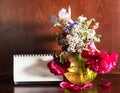 Flowers in vase and blank calendar on dark brown Royalty Free Stock Photo