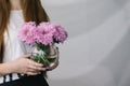 Flowers in a vase in the hands of a girl. A girl is holding a vase of flowers. Vase with Flowers.Gentle wedding bouquet in a vase.