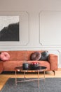 Flowers in vase and red fruits in bowl on wooden coffee table in elegant living room