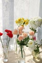 Flowers in a vase on a sunny window in a rustic house on a wooden table
