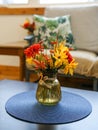 flowers in a vase on a table by a sofa couch