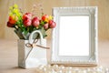 Flowers vase and vintage white picture frame. Royalty Free Stock Photo