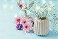 Flowers in vase with women perfume over blue retro background