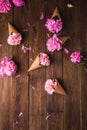 Flowers in a waffle cone. Pink carnations. Flowers on a wooden background. Copyspace. Royalty Free Stock Photo