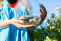 Flowers on whater inside balloon. in the hand of a woman blue dress on a outdoor summer background